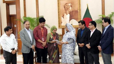 জাতীয় দলের সাবেক খেলোয়াড়ের পরিবারের হাতে পুরস্কার তুলে দিচ্ছেন প্রধানমন্ত্রী শেখ হাসিনা (ছবি: ফোকাস বাংলা)