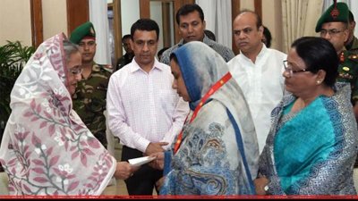 অধ্যাপক মাহবুবের স্ত্রী আলেয়া ফেরদৌসীর হাতে চেক তুলে দিচ্ছেন প্রধানমন্ত্রী 