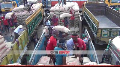 হিলি স্থলবন্দর ট্রাক থেকে চাল নামাচ্ছেন শ্রমিকেরা (ছবি&ndash; প্রতিনিধি)