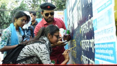 দেয়াল লিখনের ভুল বানান ঠিক করছে কাকতাড়ুয়ার কর্মীরা
