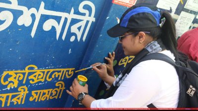 দেয়ালে লেখা ভুল বানান ঠিক করছে কাকতাড়ুয়ার কর্মীরা