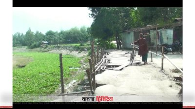 বাঁধের ধসে যাওয়া স্থানে বাঁশ ও কাঠের সাঁকো তৈরি করে চলাচল করছে স্থানীয়রা