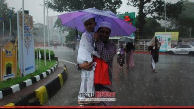 বৃষ্টির কারণে বাবার কোলে চড়ে ঈদের নামাজ পড়তে যাচ্ছে শিশুটি