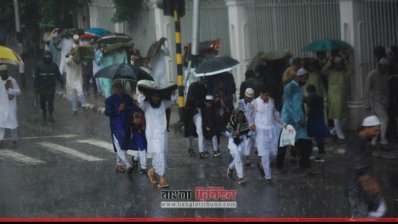 বৃষ্টিতে ভিজে জামাতে অংশ নিতে যাচ্ছেন মুসল্লিরা