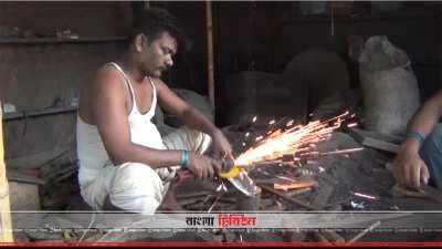 চাপাতিতে শাণ দিচ্ছেন একজন কামার