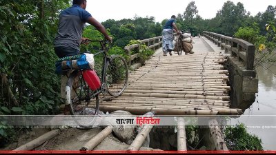 ব্রিজের পূর্বপাশের অ্যাপ্রোচের মাটি সরে যাওয়ায় স্থানীয়রা বাঁশের মাচা বানিয়ে চলাচল করছেন
