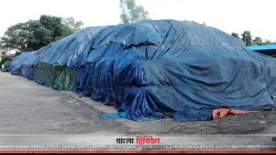খোলা আকাশের নিচে পলিথিনে ঢাকা ইউরিয়া সার