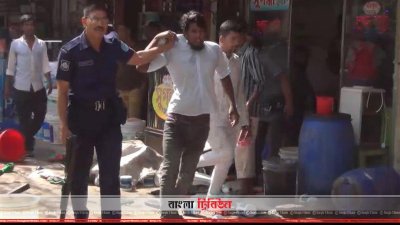 একজনকে ধরে নিয়ে যাচ্ছে পুলিশ