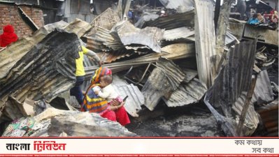 এক মা তার শিশুকে নিয়ে পুড়ে যাওয়া ঘরে কিছু খুঁজছেন