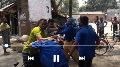 গ্রাম পুলিশ মোহাম্মদ আলীকে আঘাত করার সময় অন্যরা বাধা দেওয়ার চেষ্টা করছেন