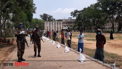 সামাজিক দূরত্ব বজায় রেখে ত্রাণ বিরতণ করা হচ্ছে