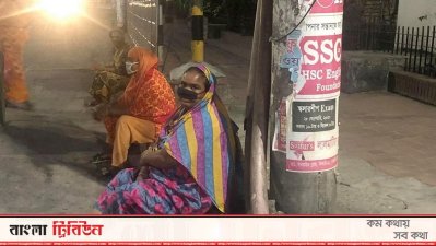 লকডাউনের ভেতর রাতের বেলা খাবারের সন্ধানে রাস্তার ফুটপাথে বসা নারী-পুরুষ