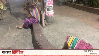 খাবারের আশায় রাতের বেলা রাস্তায় অপেক্ষমাণ নারী