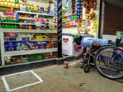 দোকানের সামনে নিরাপদ দূরত্ব বজায় রাখার ছক এঁকে দিচ্ছেন মোহাম্মদ মহসিন