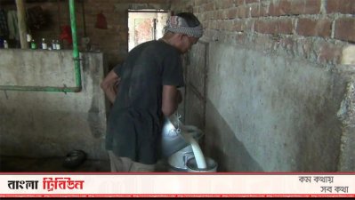 পাত্রে দুধ ঢালছেন একজন খামারি 