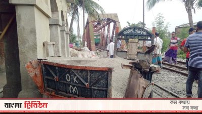 নওগাঁয় ট্রেনের ধাক্কা খেয়ে ভচকে গেছে বালুবাহী ট্রাক। ব্রিজের ভেতর আটকে গেছে ট্রেন।