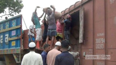 আমদানি করা পেঁয়াজের বস্তা ট্রেনের মালবাগী বগি থেকে নামানো হচ্ছে।