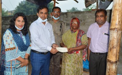 রাজশাহীর এক বিস্কুট ফেরি করা নারীকে প্রধানমন্ত্রীর অনুদান তুলে দিচ্ছে অতিরিক্ত জেলা প্রশাসক।