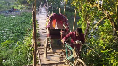 বাঁশের সাঁকো দিয়ে পার হচ্ছেন লোকজন