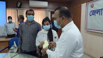 জুয়েলের মেয়ের হাতে চেক তুলে দিচ্ছেন ডিসি 