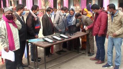 মক ভোট অনুশীলনে ভোটারদের সাহায্য করছেন একজন কর্মকর্তা।