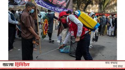 শহীদ মিনারে একজনের পা জীবণুমুক্ত করা হচ্ছে