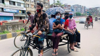 অফিসগামী যাত্রী নিয়ে ছুটছে ভ্যান