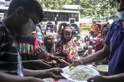 হাত বাড়িয়ে খাবার নিচ্ছেন কয়েকজন