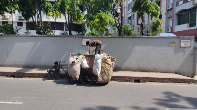 ঢাকায় ময়লার গাড়িতে পরিচ্ছন্নকর্মীর ব্যস্ততা, ছবি: সাজ্জাদ হোসেন