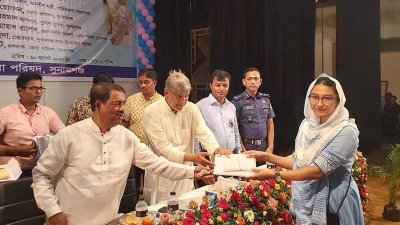 কৃতি শিক্ষার্থীর হাতে প্রাইজবন্ড ও উপহারের বই তুলে দিচ্ছেন পরিকল্পনামন্ত্রী