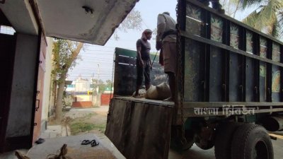 ট্রাক থেকে গম নামানোর সময় বালু ও পাথরের বস্তাগুলো পান গুদামের কর্মকর্তারা