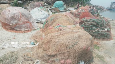 জেলেরা জাল গুটিয়ে খামাল (স্তূপ) দিয়ে রাখছেন