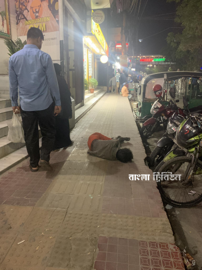 রাজধানীর শুক্রাবাদে ব্যস্ত ফুটপাতে লোকজনের চলাচলের তোয়াক্কা না করেই শুয়ে থাকতে দেখা যায় এক মাদকসেবীকে (ছবি: ফৌজিয়া সুলতানা)