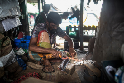 গভীর মনোযোগে ছুরিতে শান দিচ্ছেন কামার