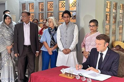 স্মৃতি জাদুঘরের স্মারক বইয়ে স্বাক্ষর করছেন ফরাসি প্রেসিডেন্ট