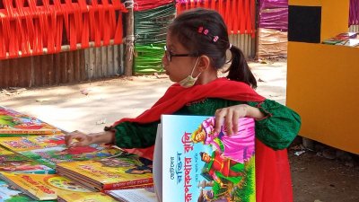 নিজের পছন্দের বই খুঁজতে ব্যস্ত এক ক্ষুদে পাঠক (ছবি: প্রতিবেদক)