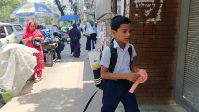 গরম থেকে বাঁচতে বাসা থেকে ছোট ইলেকট্রিক ফ্যান নিয়ে বের হয়েছেন এই শিক্ষার্থী