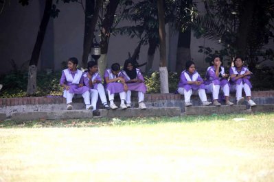 গরম থেকে খানিক রক্ষা পেতে গাছের ছায়ায় আশ্রয় নিয়েছেন তারা