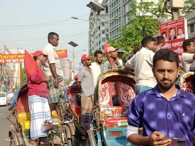 হাতে লাল পতাকা ও মাথায় লাল রঙের ক্যাপ পরে সমাবেশে যোগ দিয়েছেন রিকশা শ্রমিক দলের কর্মীরা