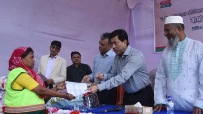 এক পরিচ্ছন্নতাকর্মীর হাতে বরাদ্দপত্র তুলে দিচ্ছেন মেয়র তাপস 