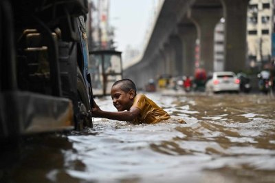 বৃষ্টির পানিতে খেলা করছে এক শিশু