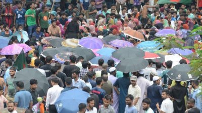 দুপুরের পর থেকেই বৃষ্টির মধ্যে অবস্থান নিয়ে দাবির পক্ষে স্লোগান দিচ্ছেন শিক্ষার্থীরা। ছবি: সাজ্জাদ হোসেন