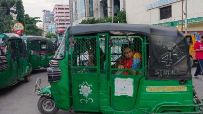 অটোরিকশায় বসে এক যাত্রী 