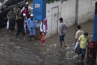 ময়লা পানি থেকে রক্ষা পেতে কাপড় গুজিয়ে রাস্তা পার হচ্ছেন তারা