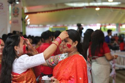 দুর্গা মাকে সিঁদুর ছোঁয়ানোর পর একে-অপরকে সিঁদুর মাখিয়ে দেন। ছবি: নাসিরুল ইসলাম