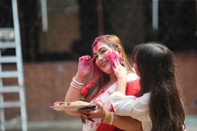 এক নারীকে সিঁদুর মাখিয়ে দিচ্ছে একটি শিশু। ছবি: নাসিরুল ইসলাম