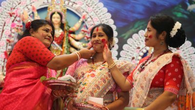 মুখ রঙিন করে হাসিমুখে মাকে বিদায় জানানোর জন্যই এই সিঁদুর খেলা। ছবি: নাসিরুল ইসলাম