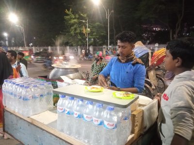 রাস্তার পাশে পিঠা বানানোতে ব্যস্ত এক বিক্রেতা