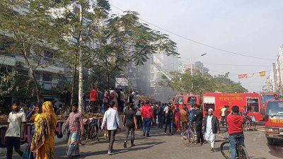 উত্তরার শাহ মখদুম রোডে লাভ লীন রেস্তোরাঁয় আগুনের ঘটনা দেখতে উৎসুক জনতার ভিড়