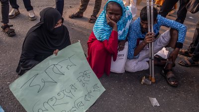 অবরোধের সময় রাস্তায় বসে আছে আহত কয়জন